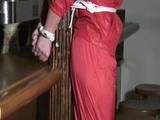 one of our archive girl tied and gagged in a shiny nylon rainsuit