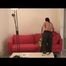 Enni lolling on a sofa wearing sexy black shiny nylon pants and a golden rain jacket (Video)