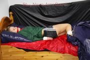 Samantha tied and gagged in bed wearing a black shiny nylon shorts and a green rainjacket (Pics)