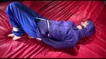 Sonja tied and gagged with ropes and a ballgag on a bed covered with a red shiny nylon cloth wearing a blue shiny nylon rain pants and a purple rain jacket (Video)