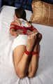 Sarah: barefoot girl in white tank-top and shorts, hogtied with hemp rope, wiggles and poses on the bed