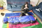 An archive girl tied and gagged in a sleepingsack by Jill on the floor both wearing shiny down jackets (Pics)