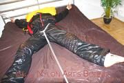 Lucy tied and gagged in a bed wearing a black shiny nylon downwear combination (Pics)