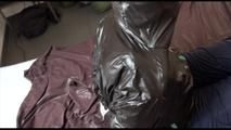 Jill tied, gagged and hooded on bed wearing a shiny black downjacket and shiny blue rain pants (Video)