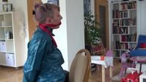 Mara tied and gagged on a chair with a bar wearing a sexy blue shiny nylon rain pants and a green rain jacket (Video)