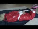 A video with Nina tied and gagged in a shiny PVC suit