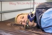Mara tied and gagged on bed with ropes and a cloth wearing hot shiny nylon shorts and rain jacket (Pics)