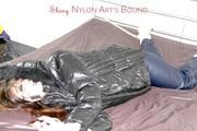 Shelly tied and gagged on a bed with downjacket and shiny rainsuit