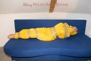 Archive girl tied and gagged by using tape on a sofa wearing an yellow rainsuit (Pics)