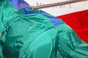 Lucy putting on linen on bed wearing supersexy green shiny nylon rainwear (Pics)