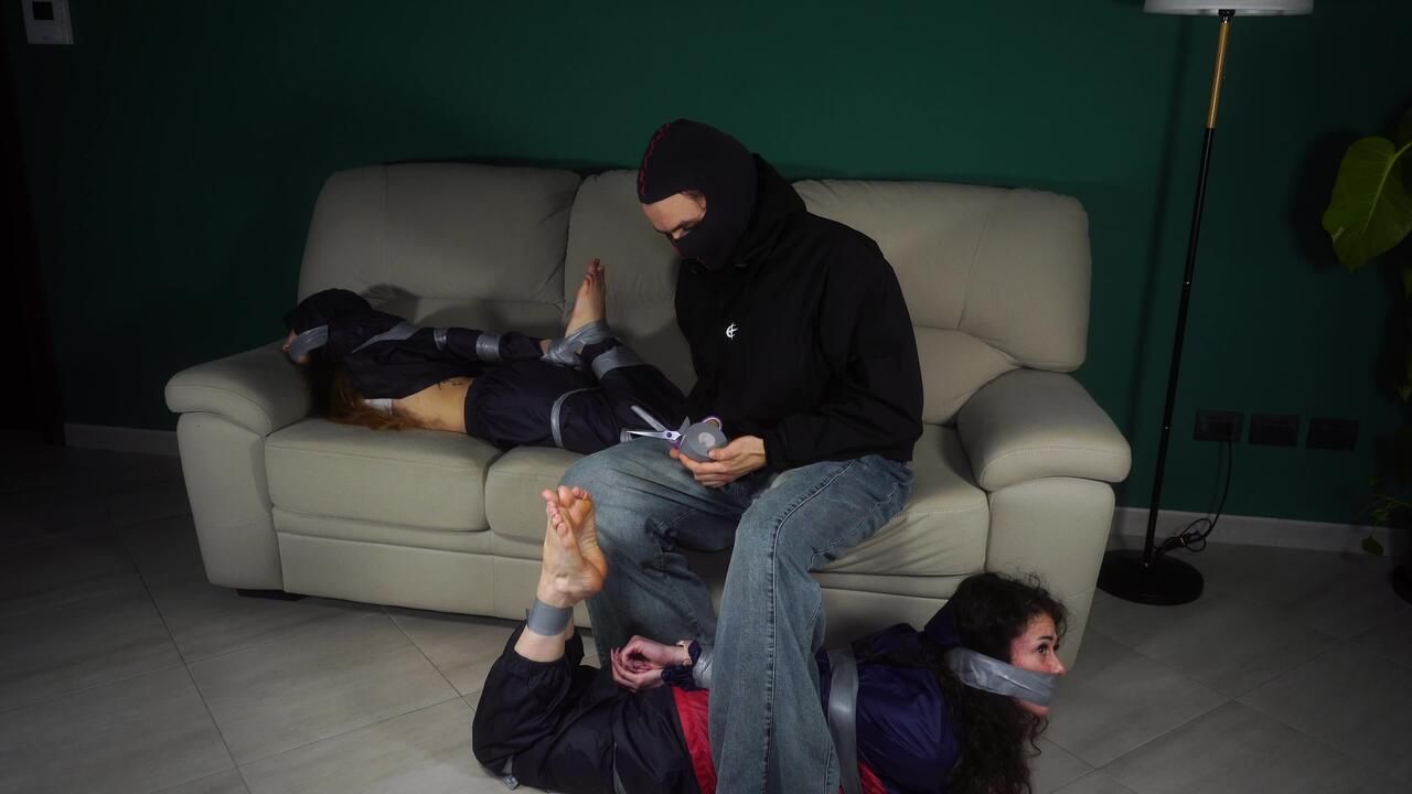 Rey Sanson And Fatima Bound And Gagged With Tape By An Intruder Wearing Rainwear. Poor Guys. They Had Differebt Plabs For The Evening But End Up Both Tied And Gagged Tightly, Struggeling To Get Free