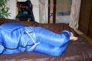 Jill tied, gagged and hooded on bed wearing a supersexy supershiny lightblue downwear (Pics)