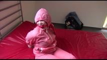Jill tied, gagged and hooded on a bed wearing sexy pink shiny rainwear (Video)