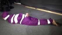 Sexy Sandra wearing a supersexy purple shiny nylon rainsuit bein tied and gagged and hooded on the floor with tape (Video)