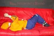 Lucy tied and gagged on a sofa wearing an orange shiny nylon rain jacket and a blue rain pants (Pics)