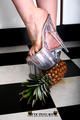 Heels crushing pineapple in the kitchen