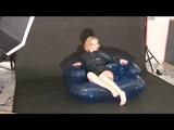 Blonde archive girl posing on a blowable chair wearing shiny nylon shorts and a rain jacket (Video)