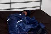 Simone tied and gagged in a shiny nylon rainsuit and a shiny nylon cape