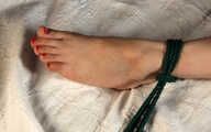 Barefoot tapegagged Grace in grey lace polka dot bra and panties, tied on the bed with her hands and legs wide-spread, wiggles helplessly