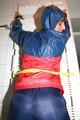 Stella tied, gagged and hooded on an radiator wearing a shiny red/blue rain combination (Pics)