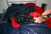 Alina tied and gagged in red nylon shorts and a shiny black jacket