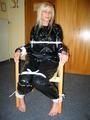 One of our archive girls tied and gagged in a shiny black PVC saunasuit