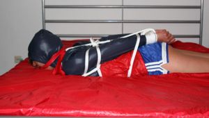 Alina bound in blue shorts and a shiny jacket