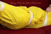 Mara tied, gagged and hooded with tape on a red sofa wearing shiny yellow rainwear (Pics)
