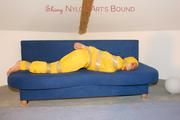 Archive girl tied and gagged by using tape on a sofa wearing an yellow rainsuit (Pics)