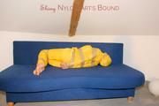 Archive girl tied and gagged by using tape on a sofa wearing an yellow rainsuit (Pics)