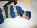 One of our archive girls bound and gagged in a blue shiny rainsuit 