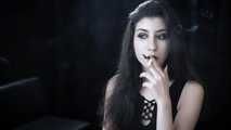 Goth girl with black eyes occasionally prefers dragging a 120mm cigarette
