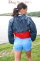 Sexy archive girl walking on a lake wearing a sexy shiny nylon shorts and an oldschool rain jacket (Pics)