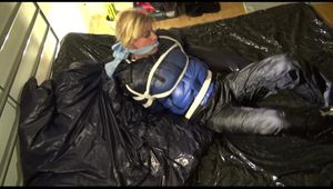 Pia tied, gagged and hooded lying on a bed with shiny nylon cloth wearing a sexy black adidas nylon pants and a blue down jacket(Video)