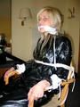 One of our archive girls tied and gagged in a shiny black PVC saunasuit