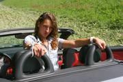 Stella tied and gagged in a grey shiny nylon catsuit in a car